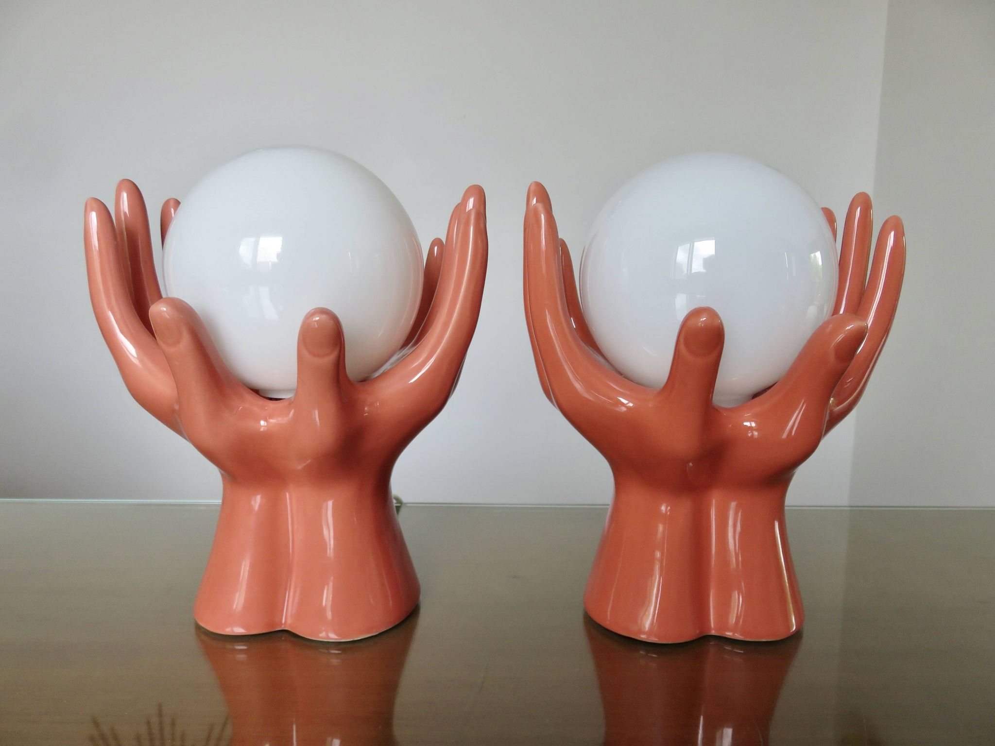 Pair of salmon-colored ceramic "hand" lamps with opaline globe, 80