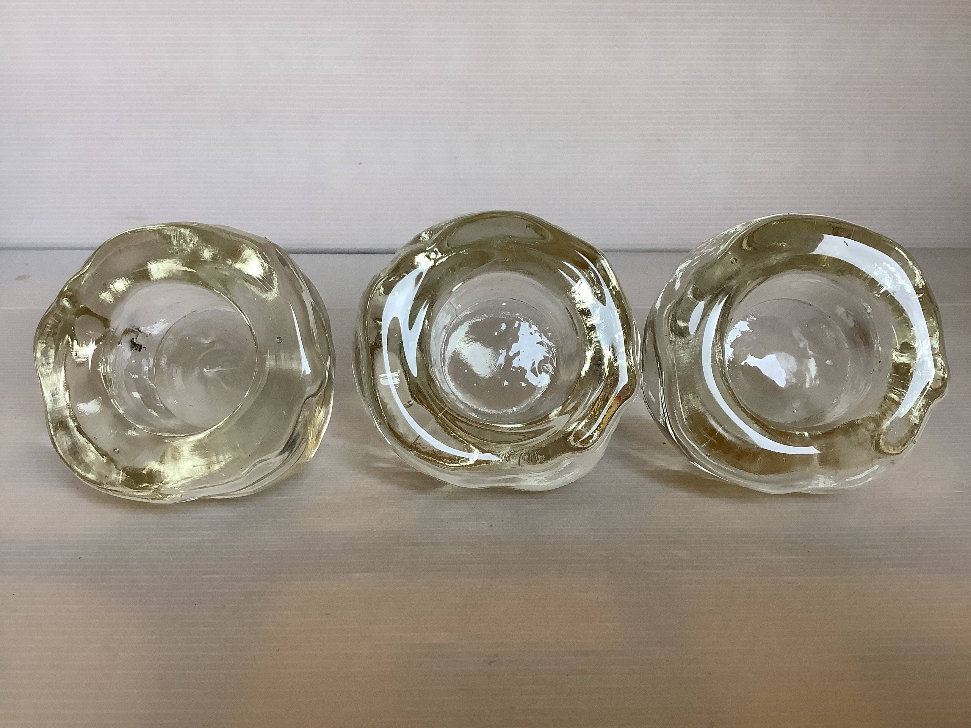 Set of three thick moulded glass candle holders.
