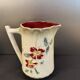 Antique pitcher in slipware with floral decoration – red and cream floral design