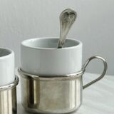 2 porcelain cups with metal supports and small spoons.