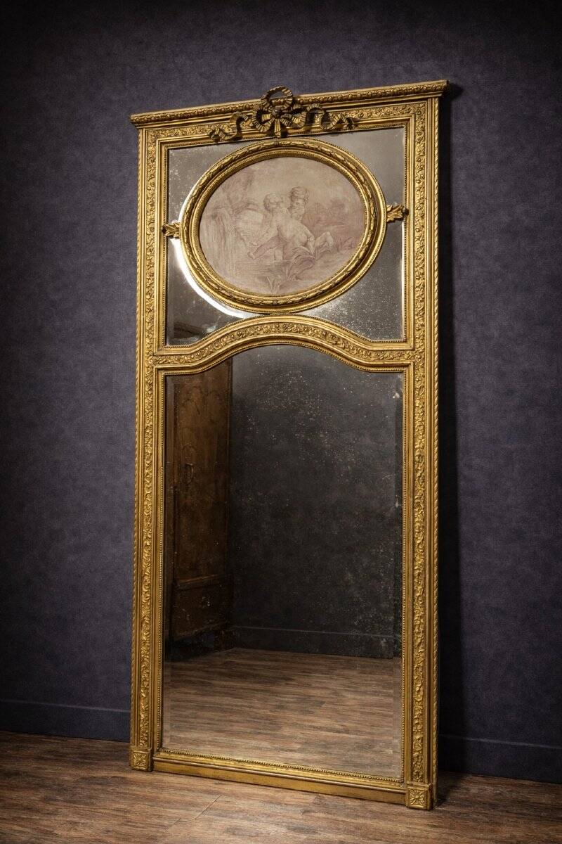 Very large mirror with mouldings, richly carved and gilded, in the Louis XVI style.