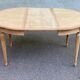Extendable round table in renovated Louis XVI style, made of light wood, with 2 extensions.