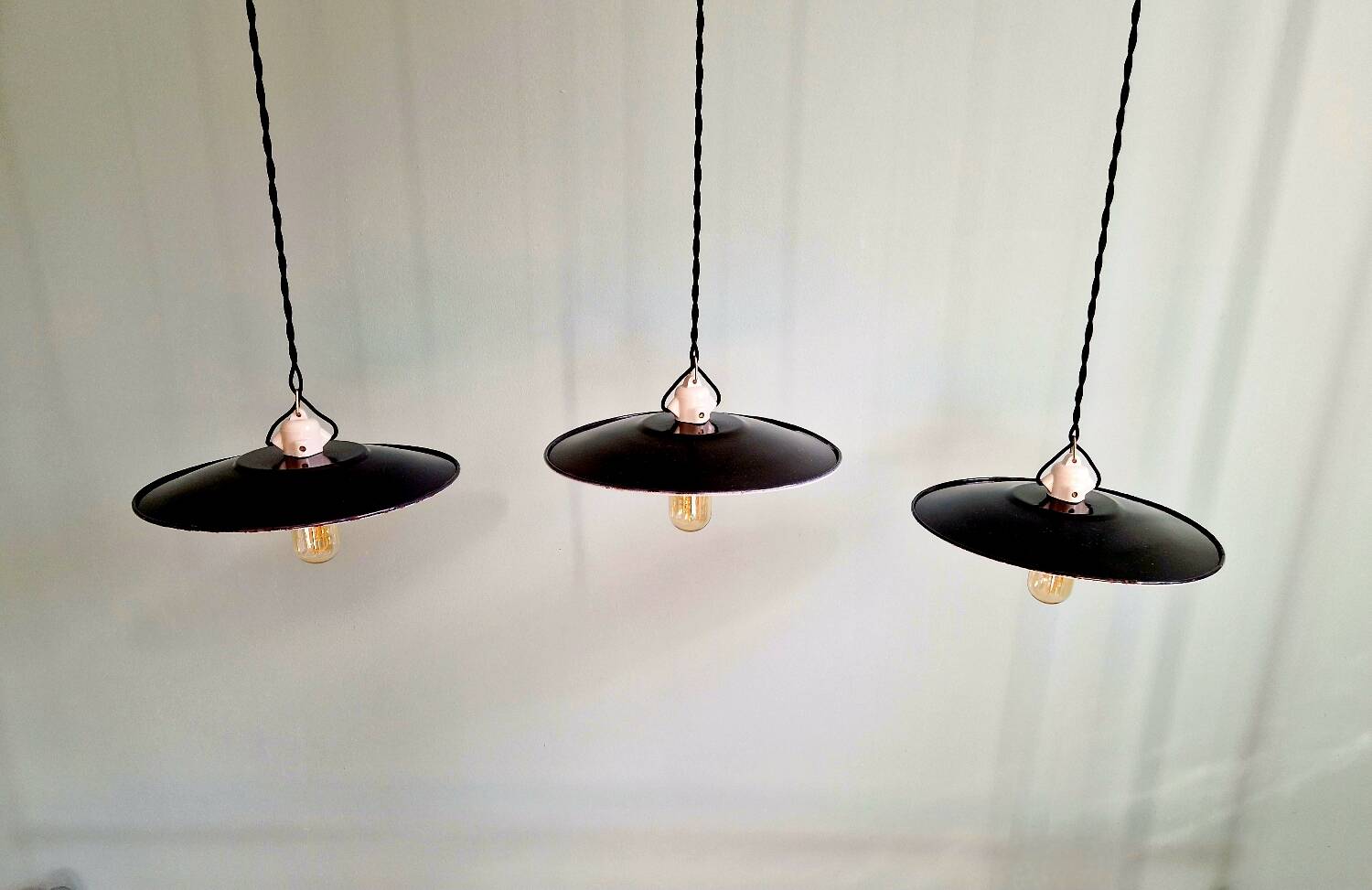 Three industrial suspensions in black enamelled sheet metal.