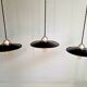 Three industrial suspensions in black enamelled sheet metal.