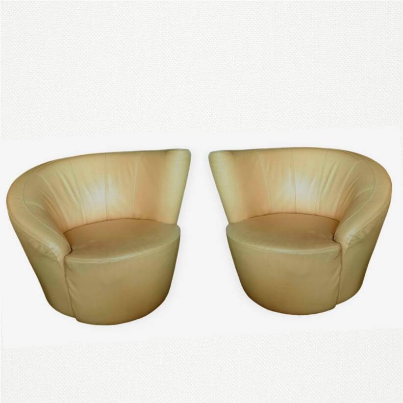Pair of yellow leather swivel armchairs with asymmetrical armrests, circa 1980