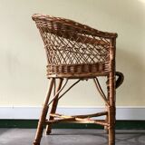 Woven rattan armchair with armrests.