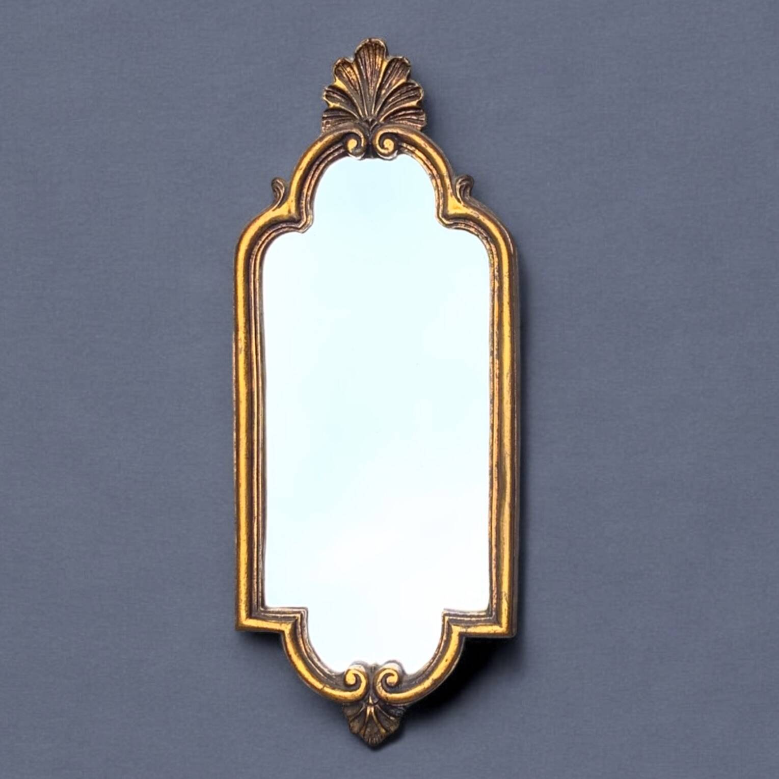 Old small wall mirror in golden resin