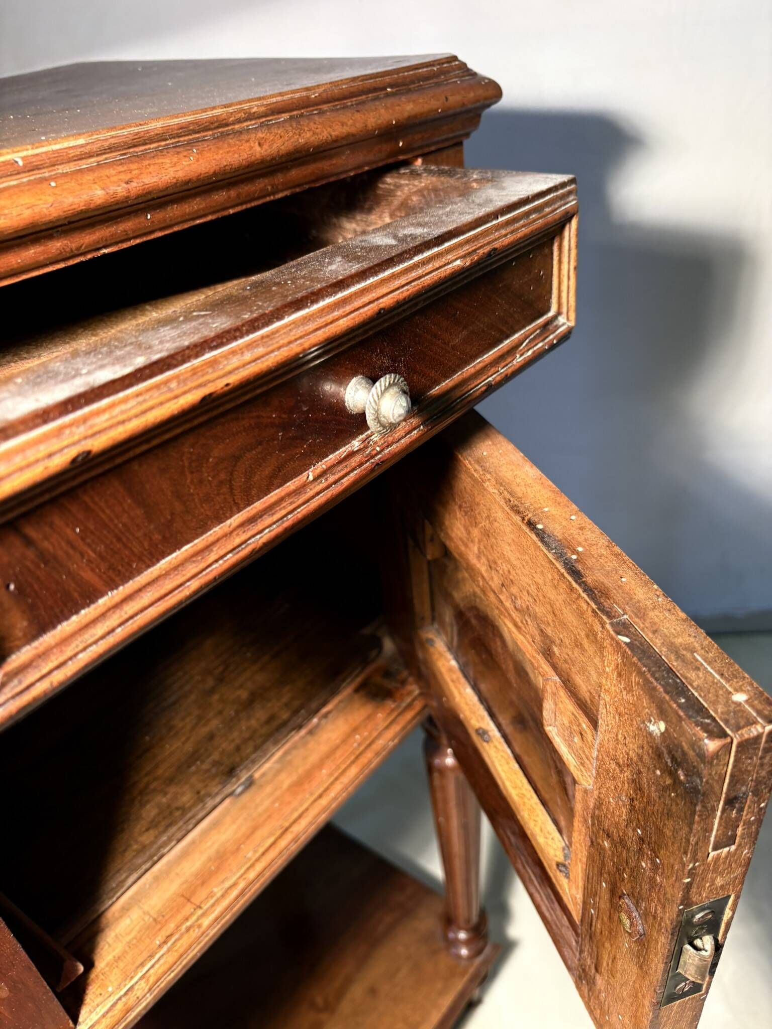 Antique wooden bedside table with turned legs.