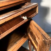 Antique wooden bedside table with turned legs.