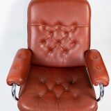 Armchair upholstered with red leather and frame of metal, of danish design from the 1960s