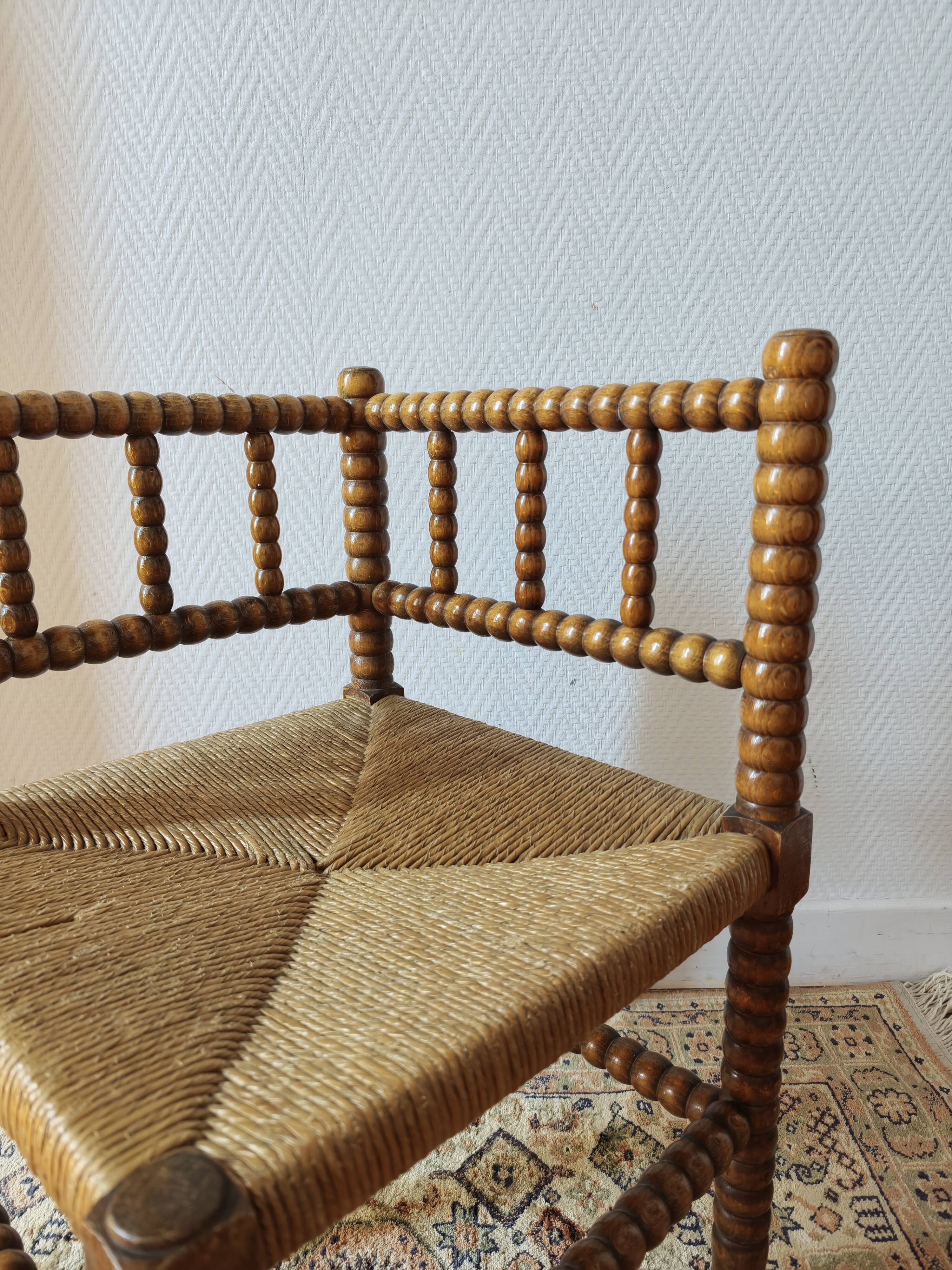 Antique corner chair by the fire with turned wood and straw seat.