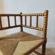 Antique corner chair by the fire with turned wood and straw seat.