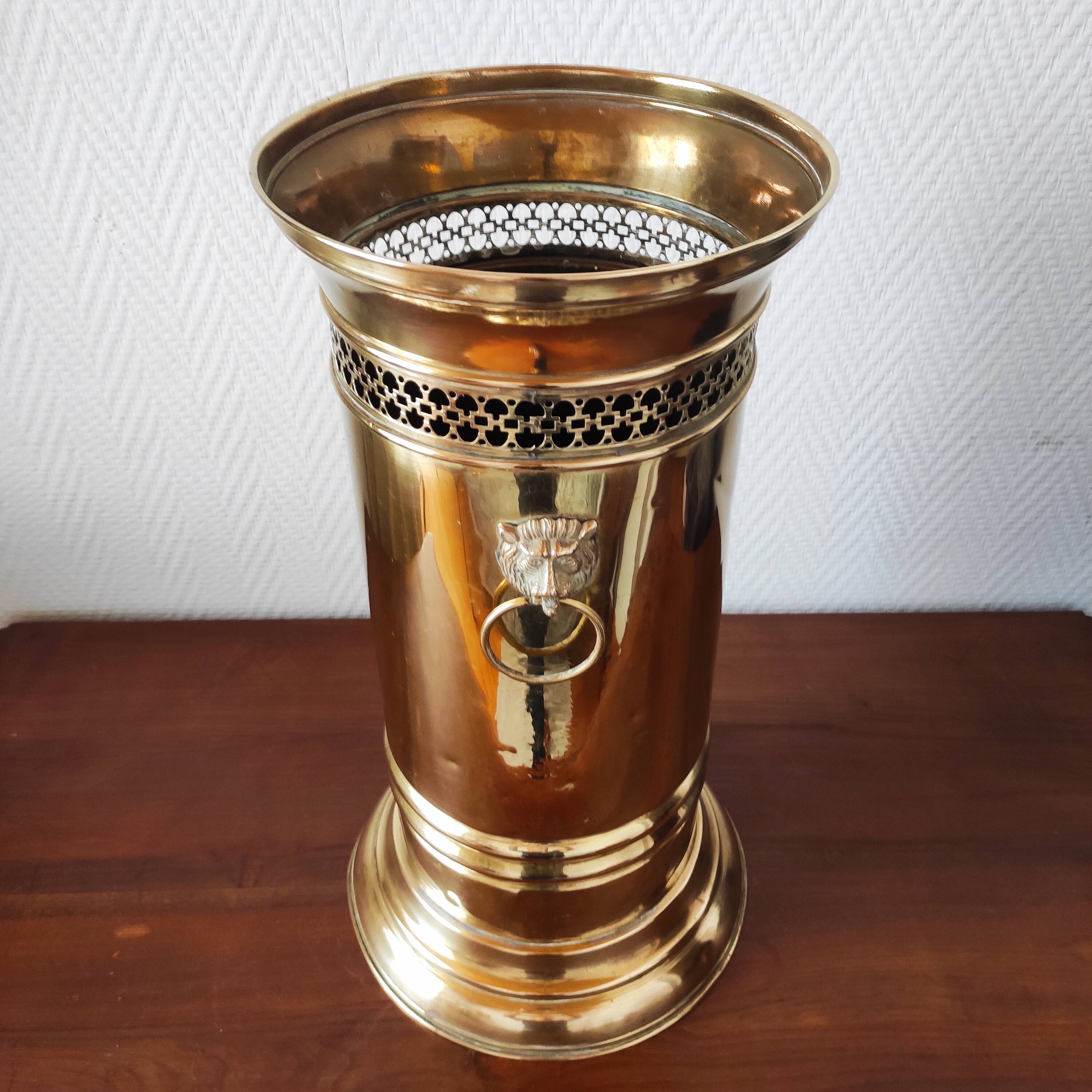 Vintage brass umbrella stand with lion decoration.