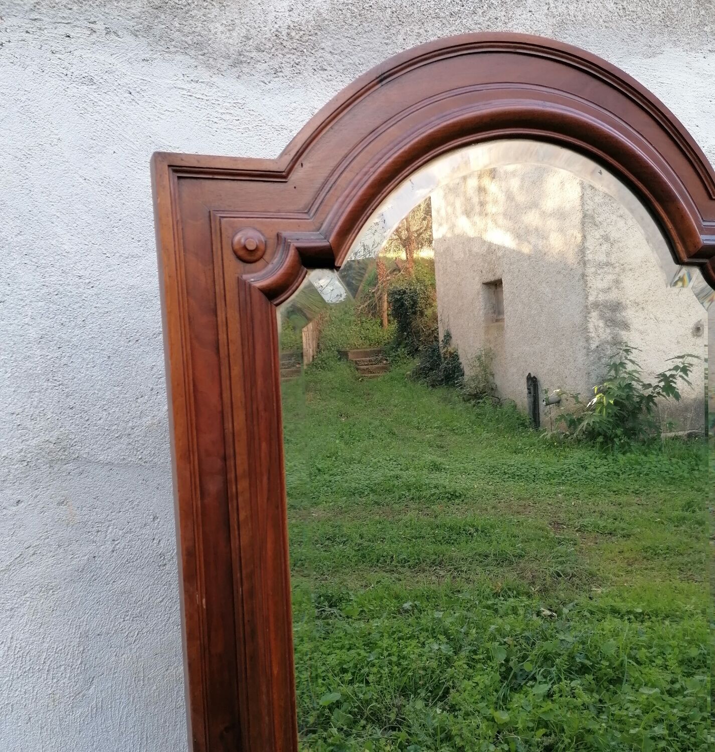Old beveled solid wood mirror of a cabinet door.