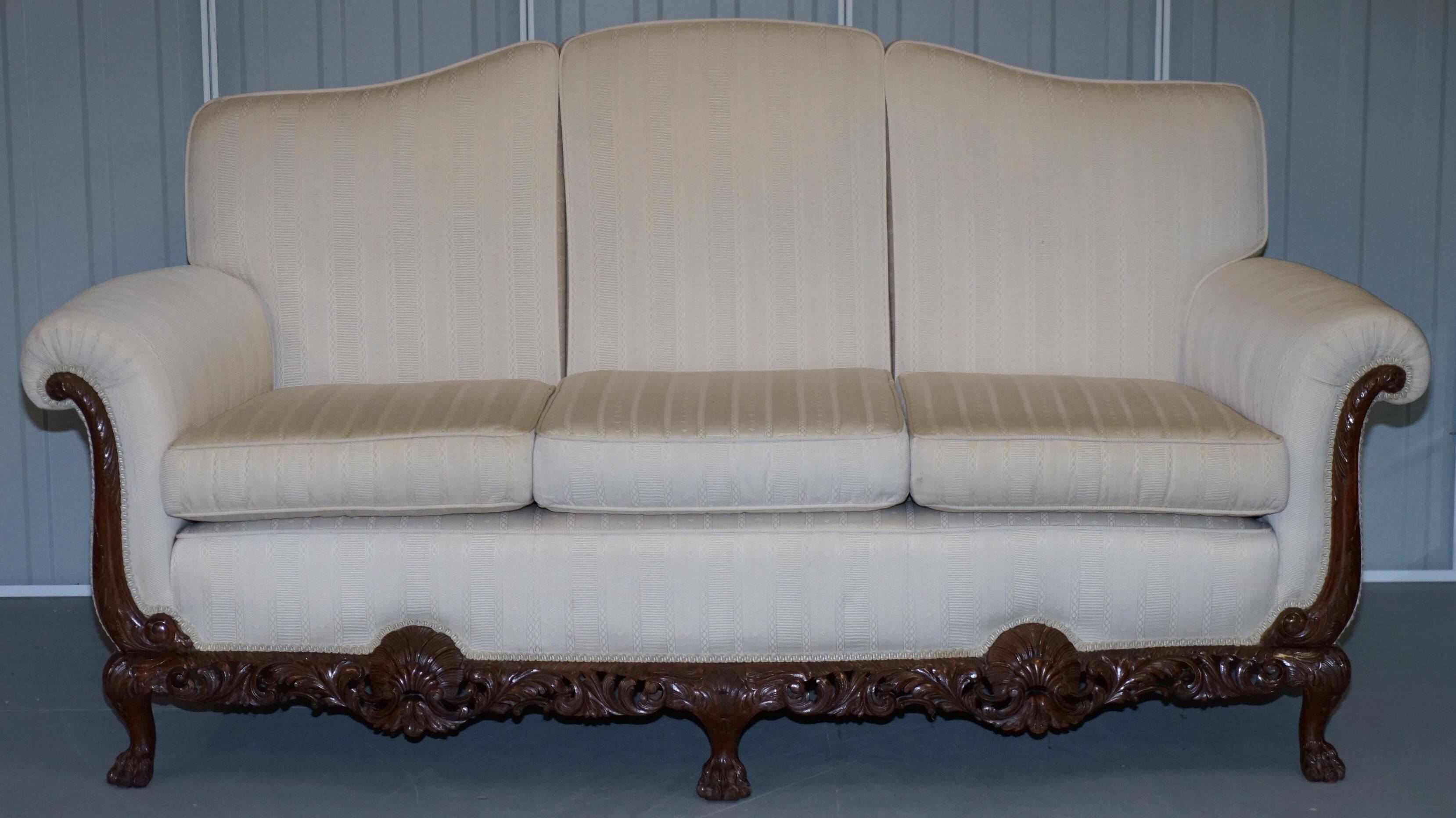 Three-seater canapé carved from solid walnut with claw feet.