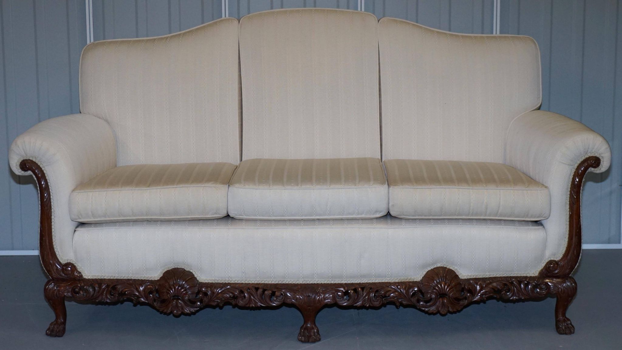 Three-seater canapé carved from solid walnut with claw feet.