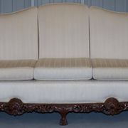 Three-seater canapé carved from solid walnut with claw feet.