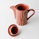 Vintage tea or coffee service in 1970s ceramic, teapot with lid and milk jug, rust orange with retro striped pattern, mid-century decoration, gift idea.