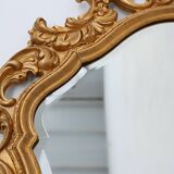 French Rococo or Baroque style facet-cut crest mirror in gilded carved wood