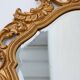 French Rococo or Baroque style facet-cut crest mirror in gilded carved wood