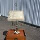 Two-armed hot water bottle lamp in silver metal with fringed fabric shade