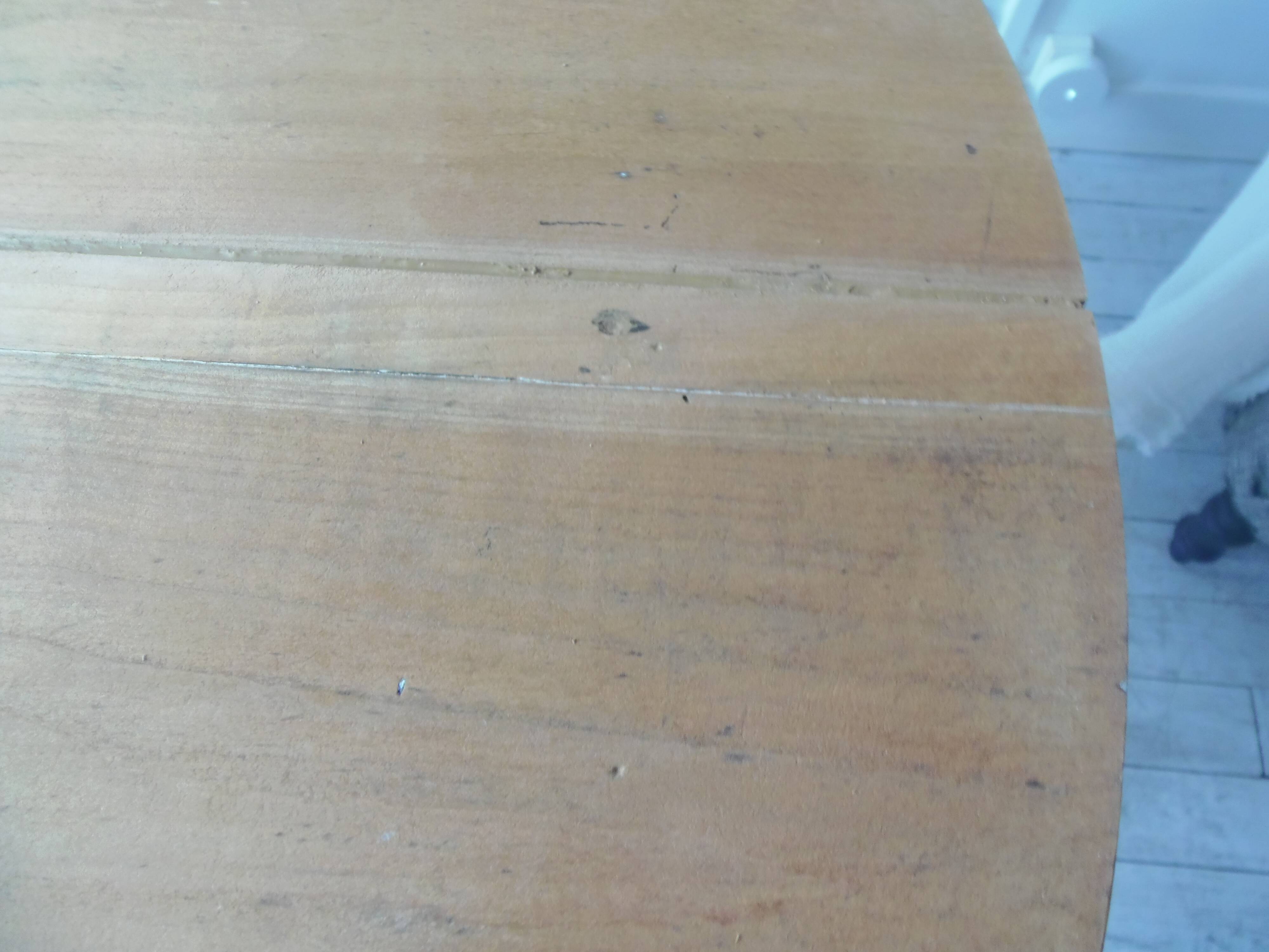 Walnut table with raised flaps, base on verdigris casters.