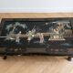 Table basse chinoise en bois laqué noir et décor doré