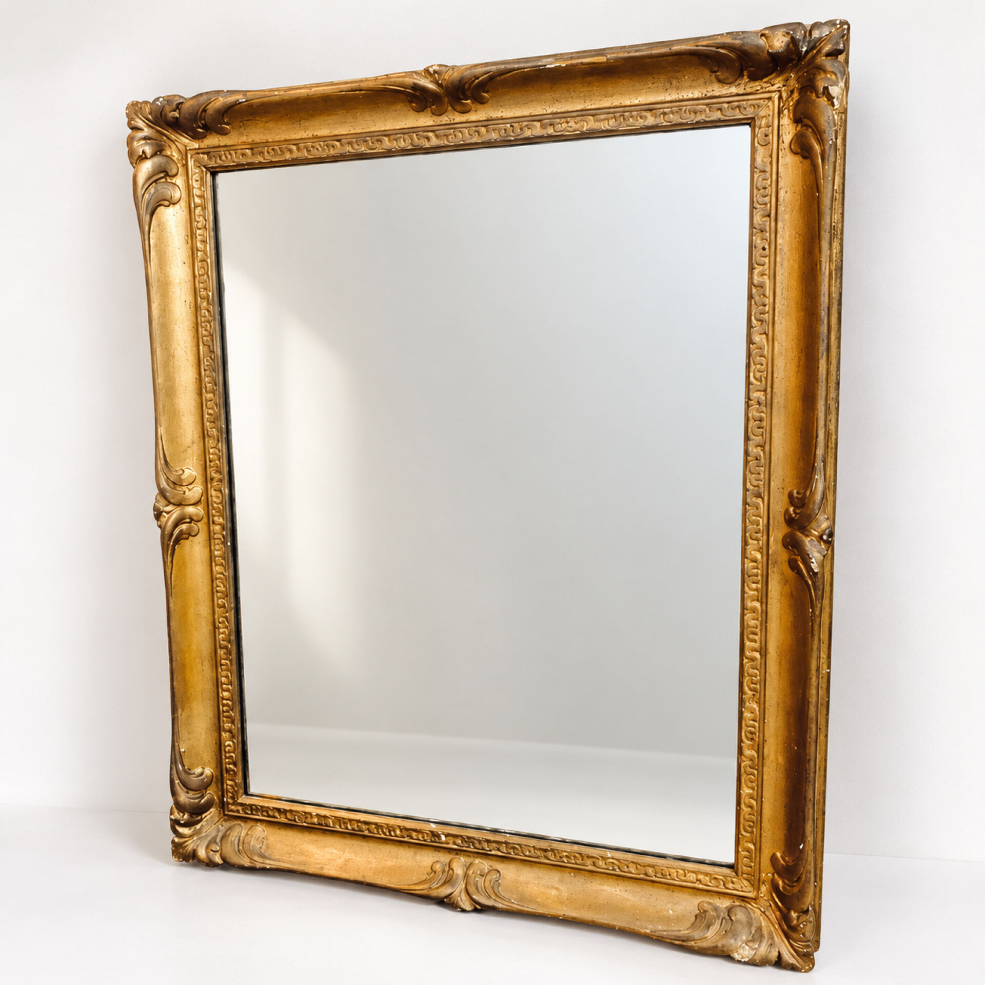 Antique mirror with a gilded frame and foliage decoration.