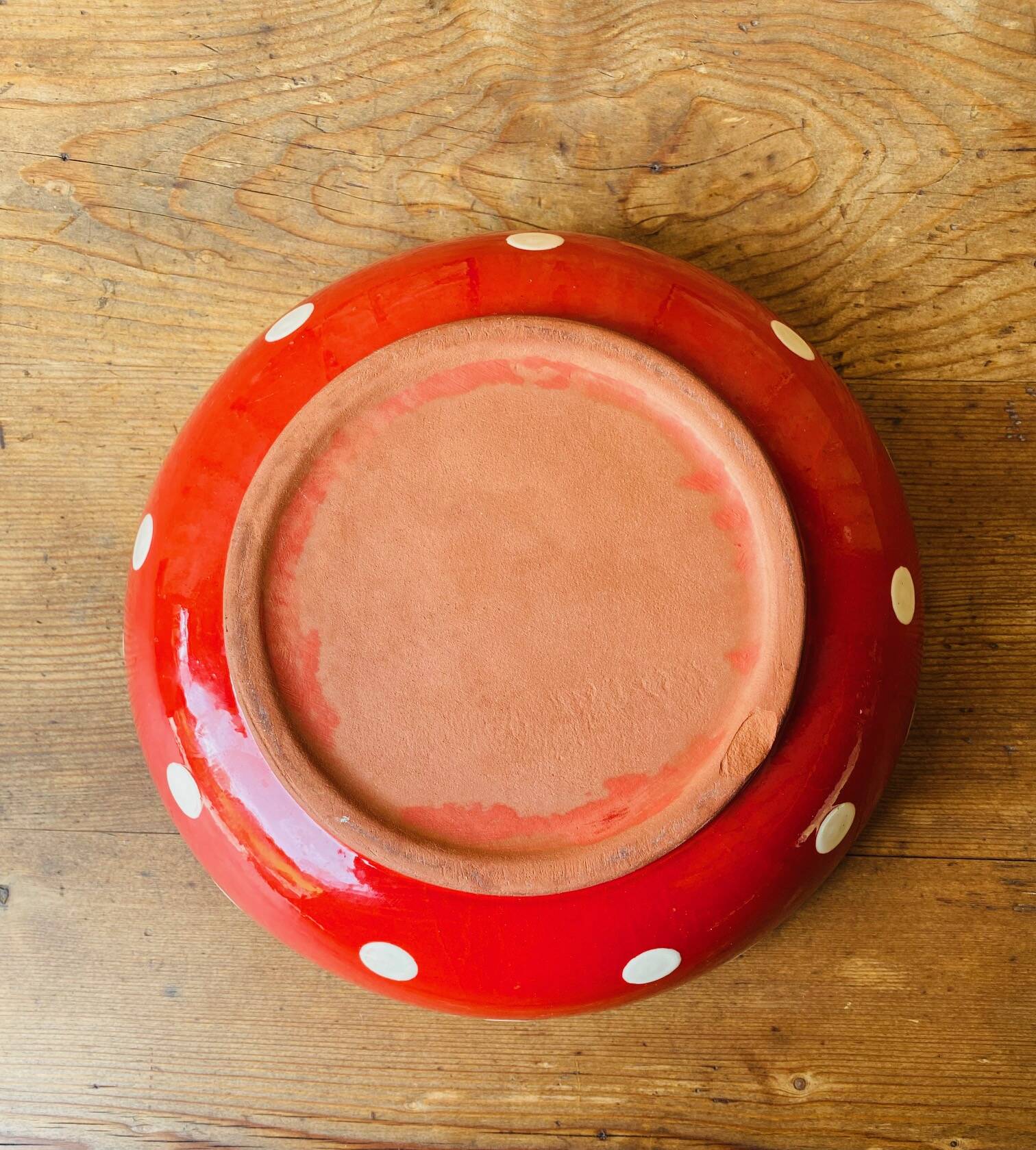 Ceramic salad bowl in red with white polka dots.