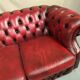 Three-seater curved red leather chesterfield sofa