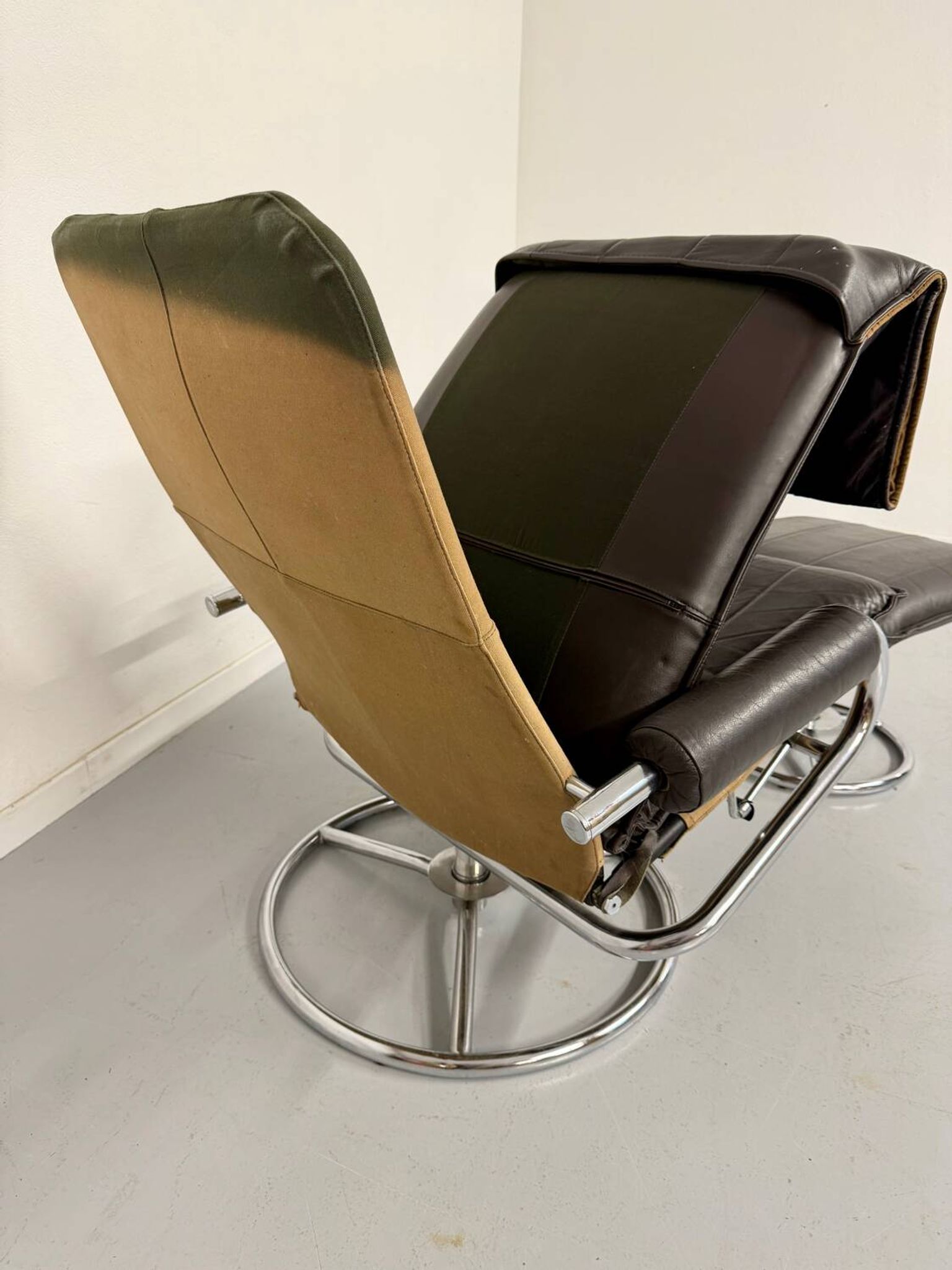 Vintage leather reclining armchair and its 1970s designer ottoman.