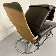 Vintage leather reclining armchair and its 1970s designer ottoman.