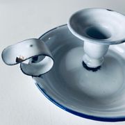 Old candle holder in white enameled metal