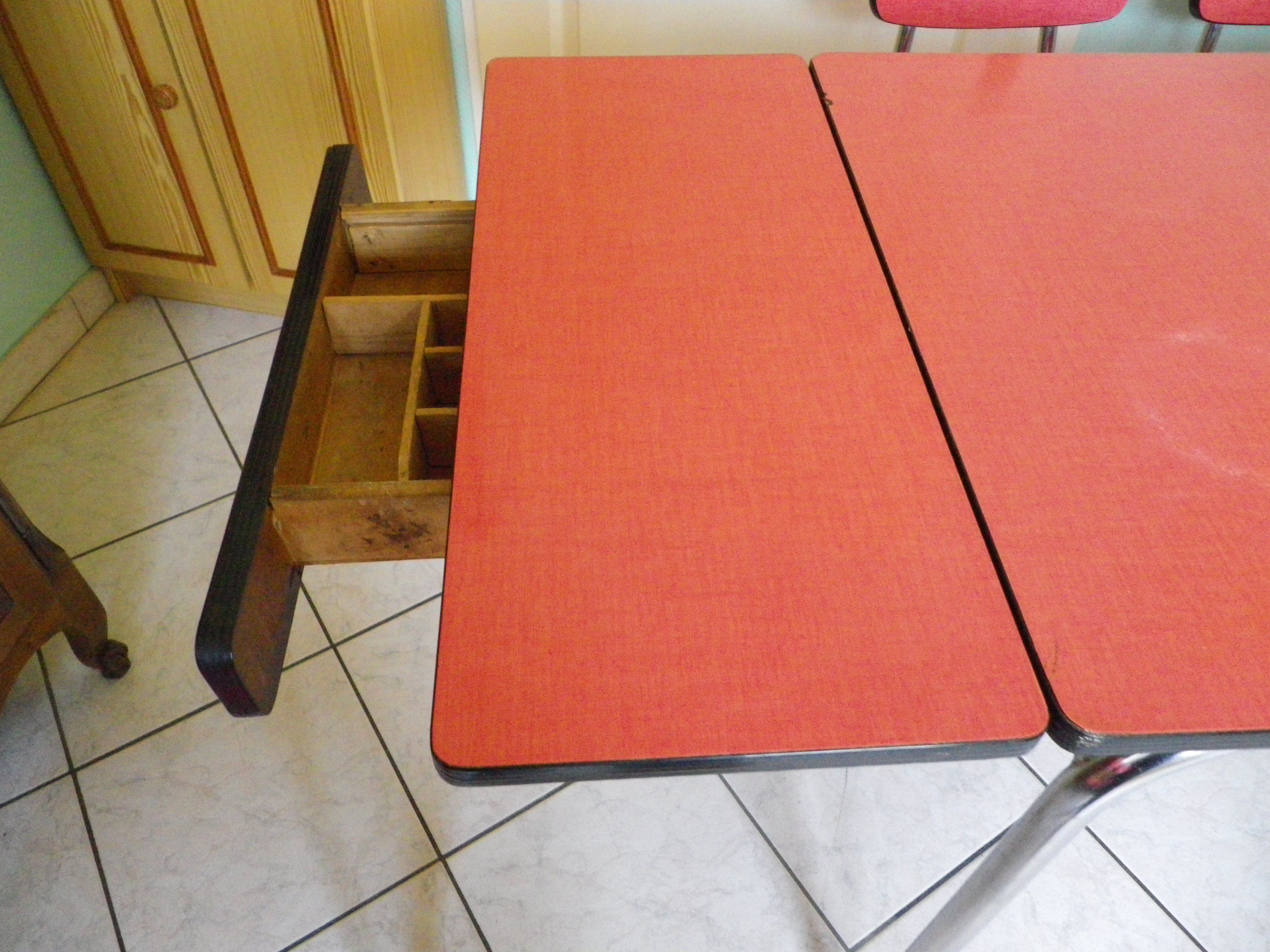 Table in red formica, 4 roc chairs, 2 extension cords, 2 drawers 60