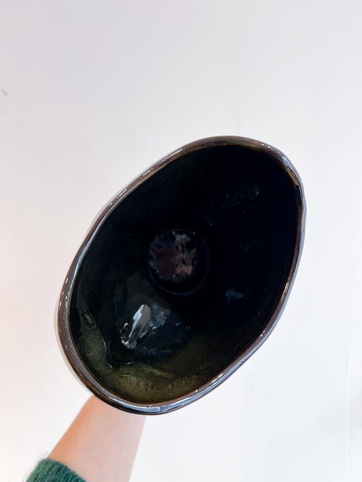 Black ceramic vase with a woman's face.