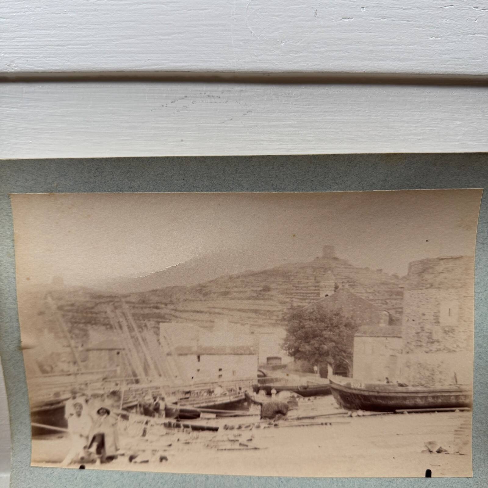 Photo album glued onto cardboard depicting a 19th-century port.