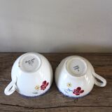 A set of two Digoin earthenware cups with blue, red, and yellow flowers.
