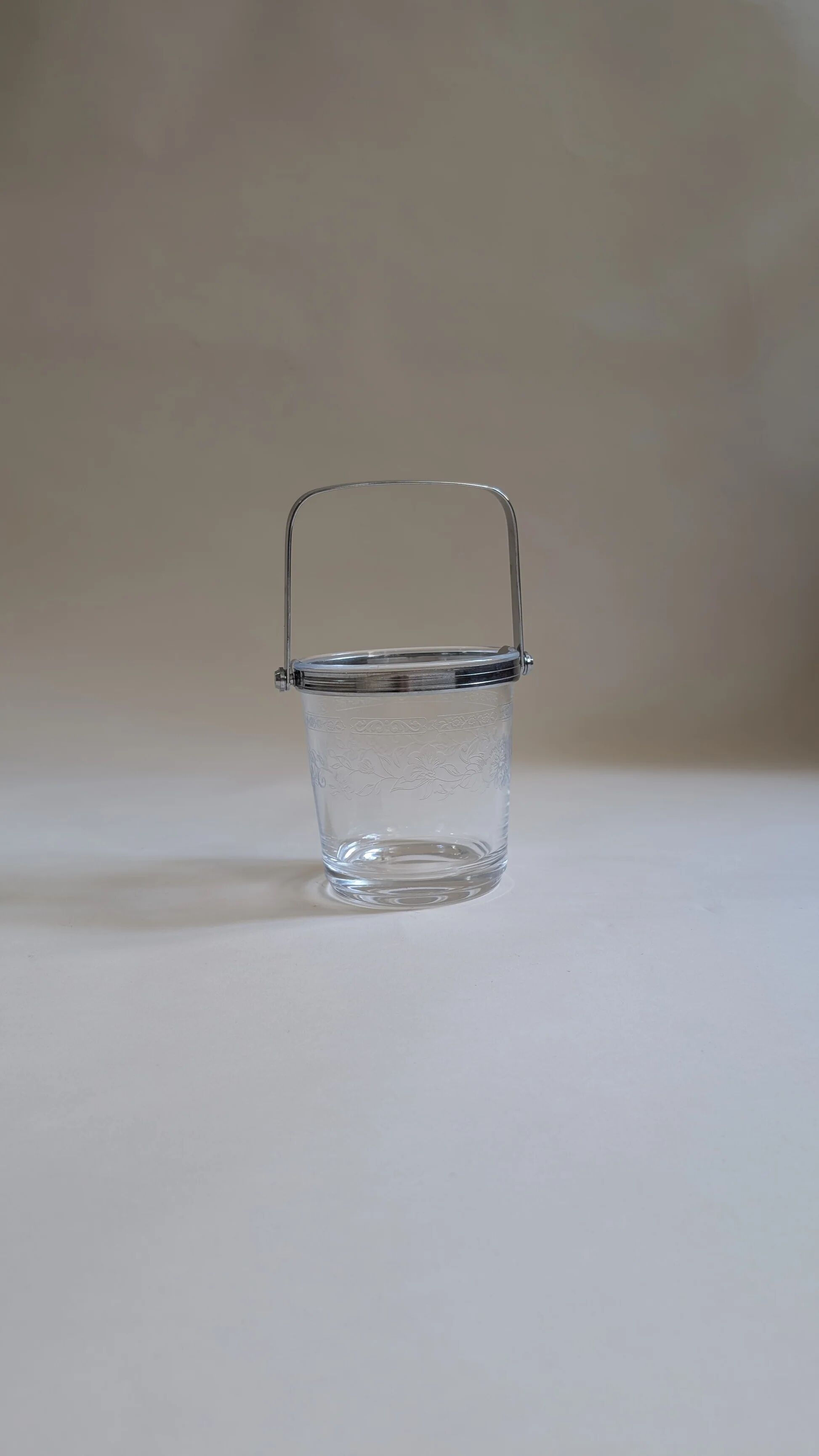 Clear glass ice bucket with an etched floral design