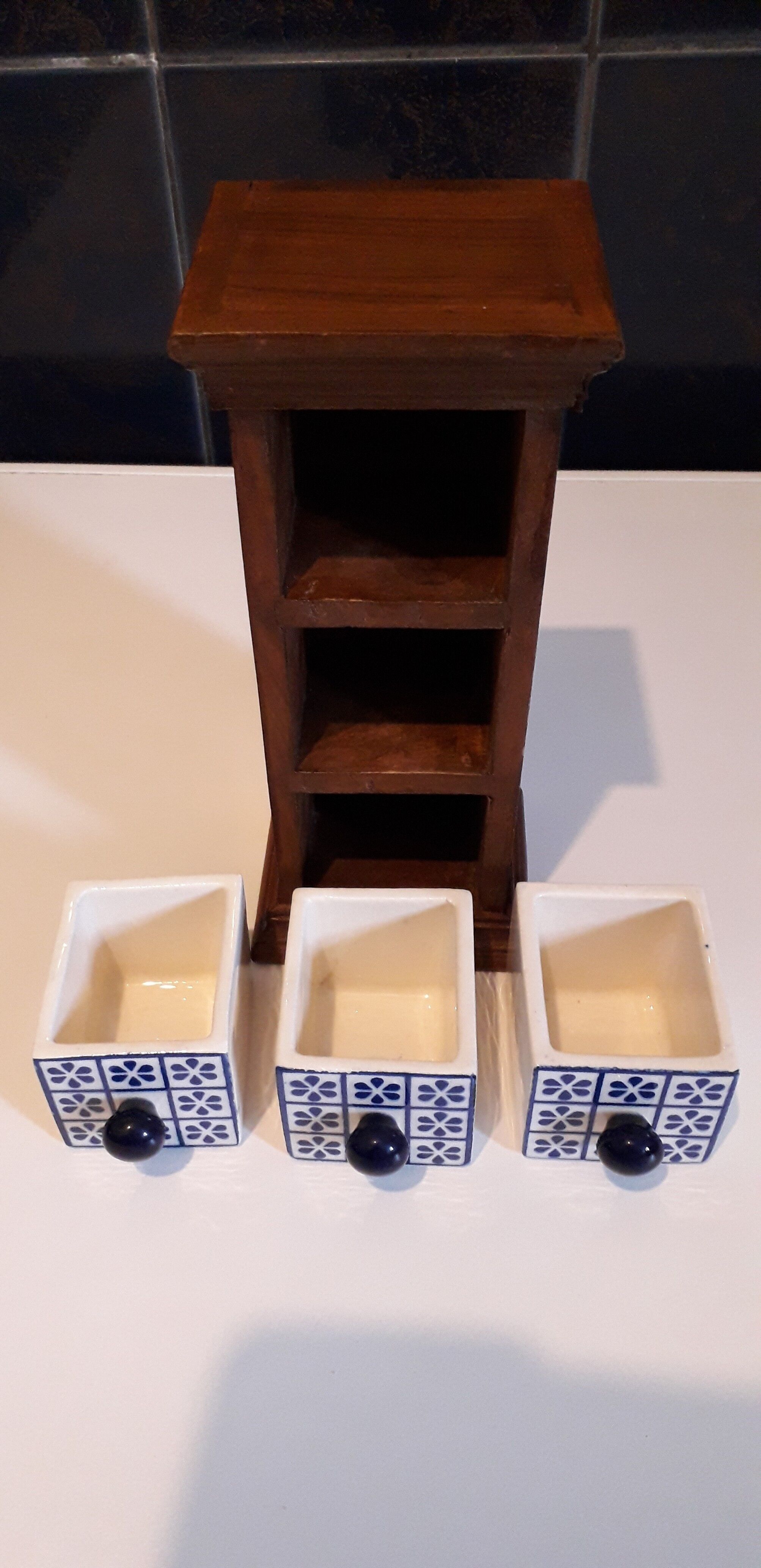Storage in the form of a small wooden cabinet, with 3 ceramic drawers.