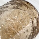 Translucent pinkish iridescent cracked glass bottle.