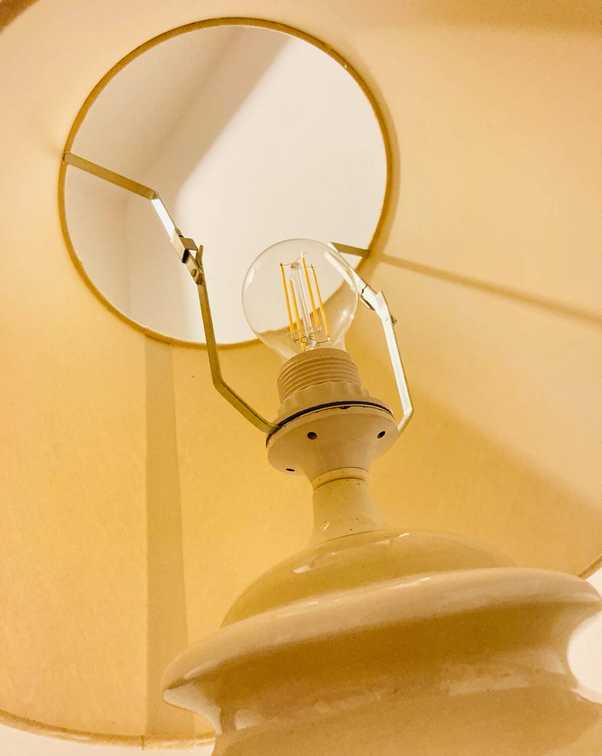 1980s ceramic table lamp with a wooden base and adjustable shade.