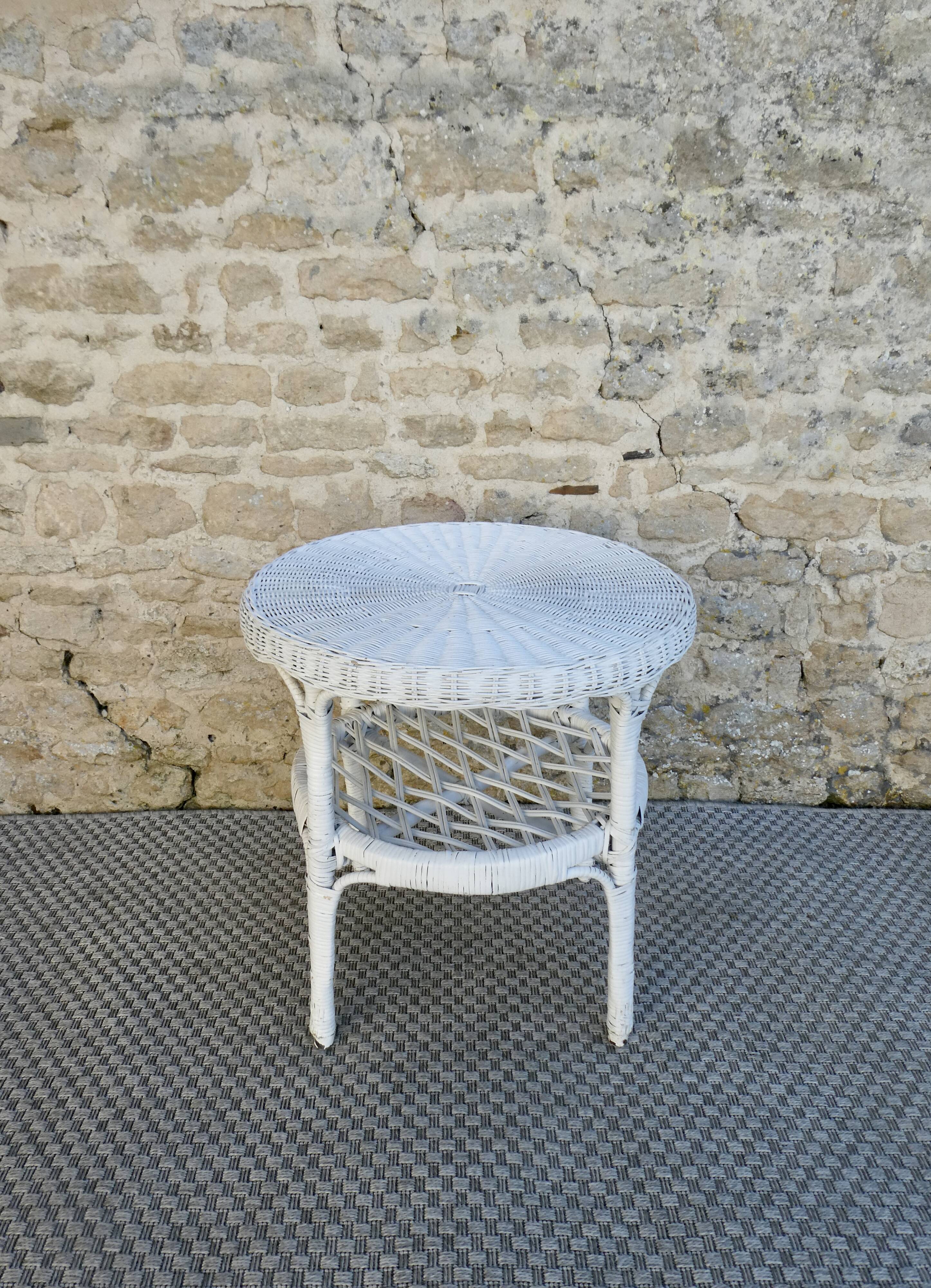 Round white rattan side table with storage underneath, circa 1970.