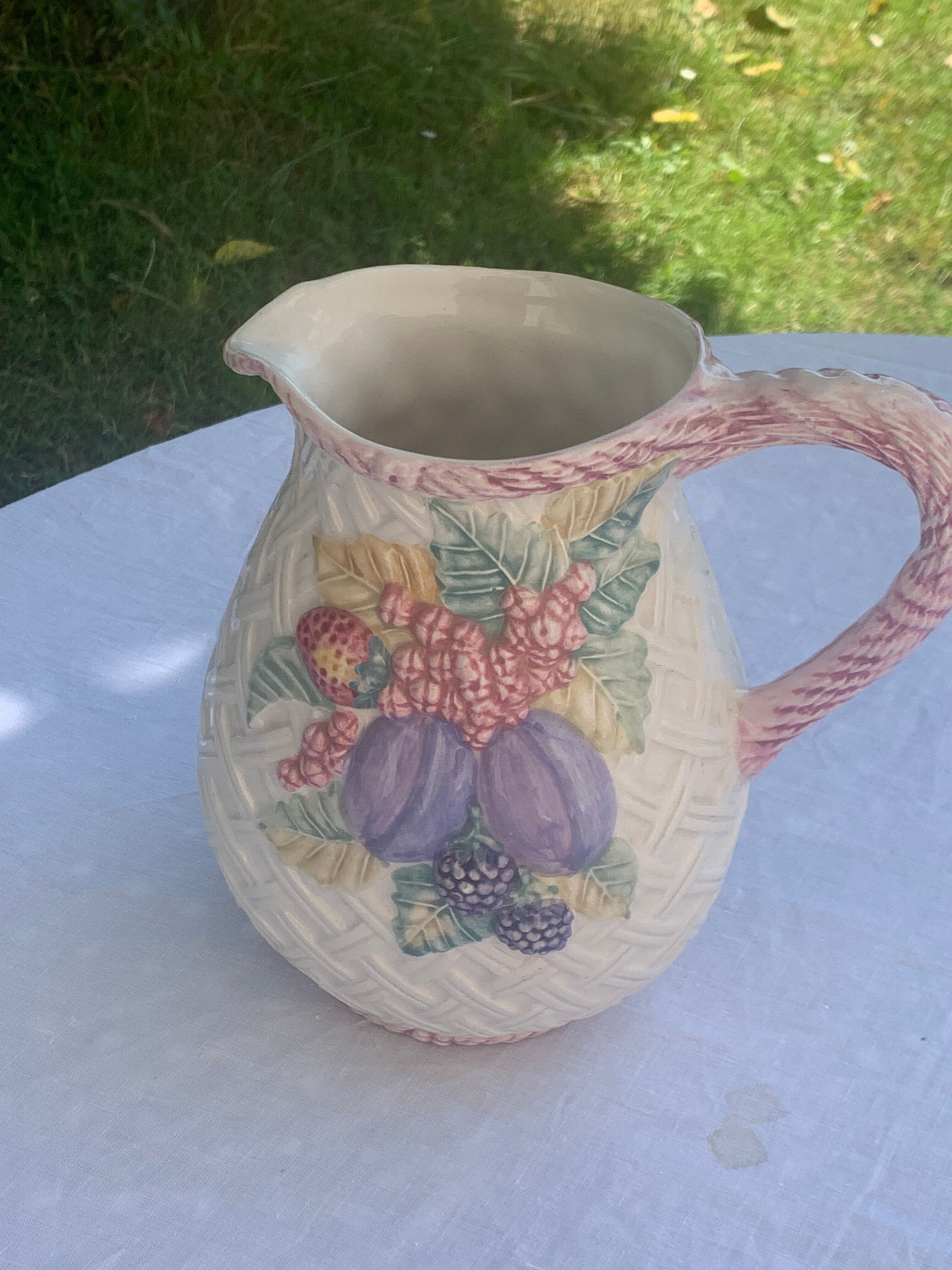 Glazed ceramic slip jug with vintage basket and fruit motif