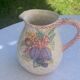Glazed ceramic slip jug with vintage basket and fruit motif