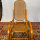 Antique rocking chair in curved wood and caning.