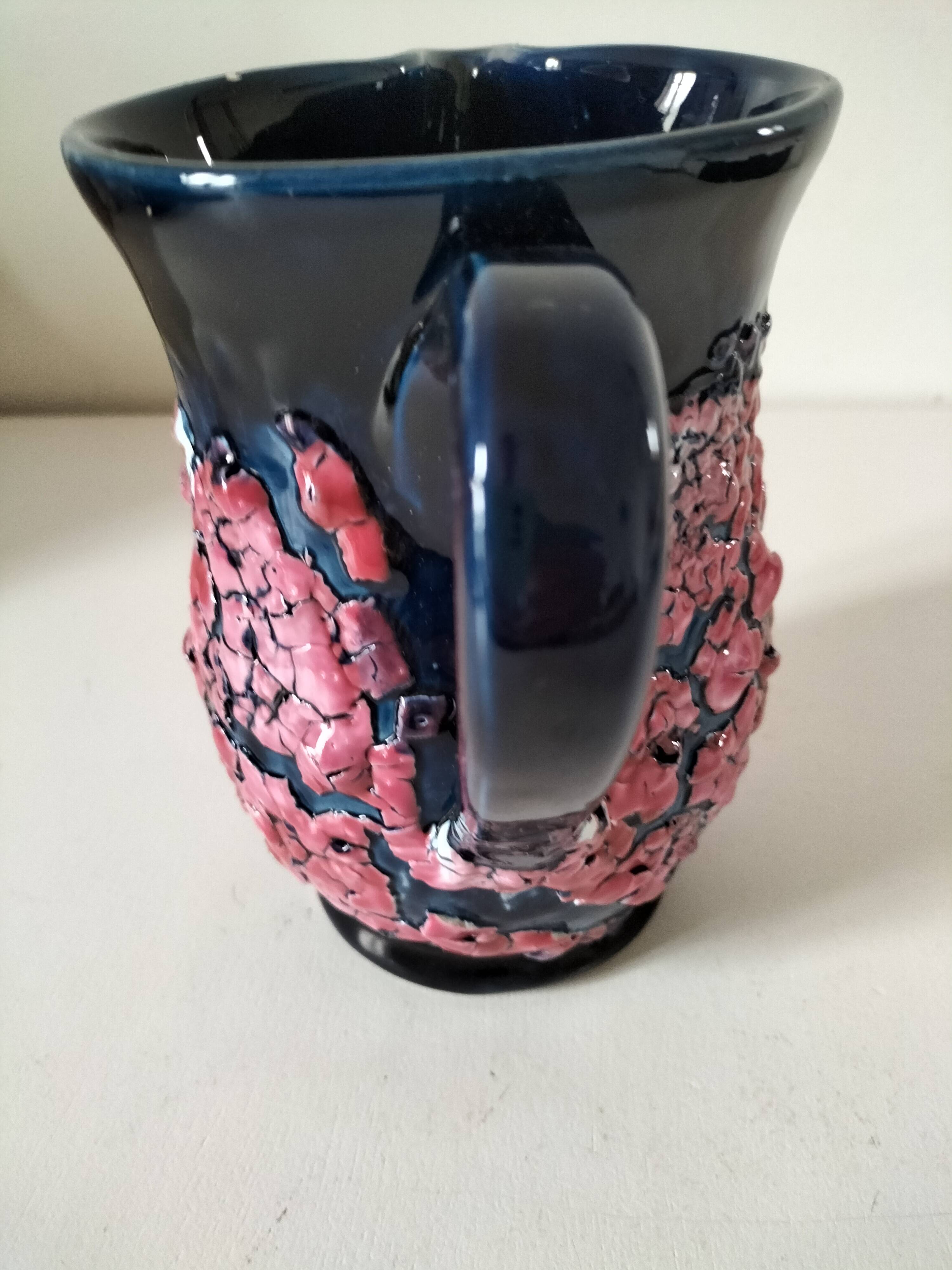 Vintage pitcher in midnight blue glazed ceramic with bright pink relief