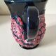 Vintage pitcher in midnight blue glazed ceramic with bright pink relief