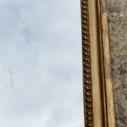 Antique mirror in wood and gilded stucco with a pediment - in the style of the 18th century.