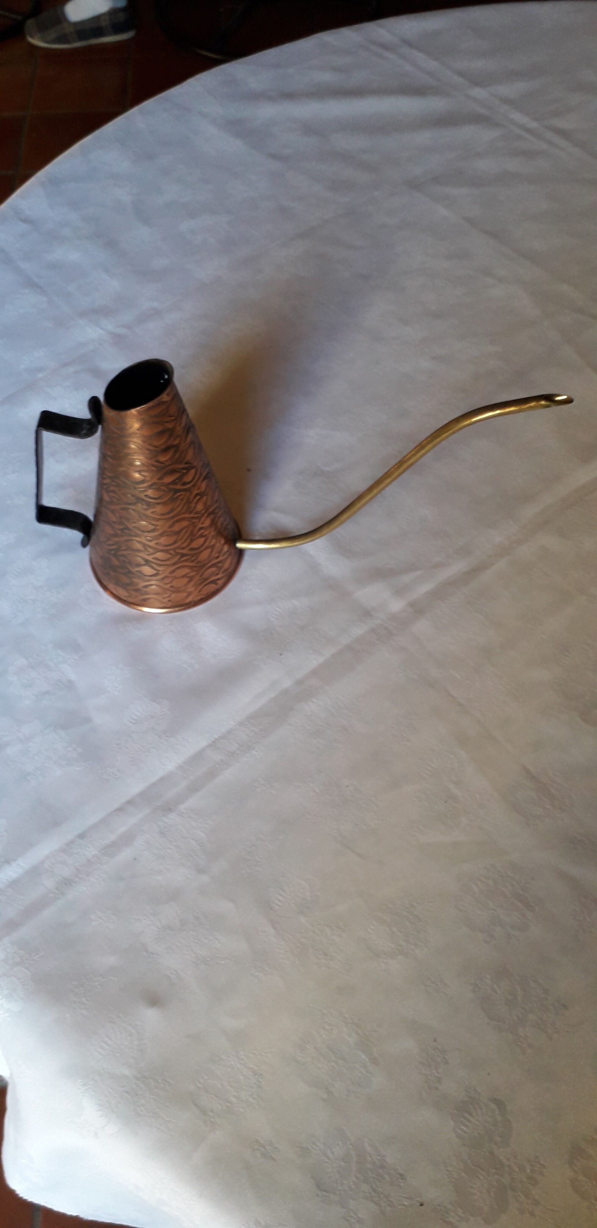 Old watering can in red copper and brass