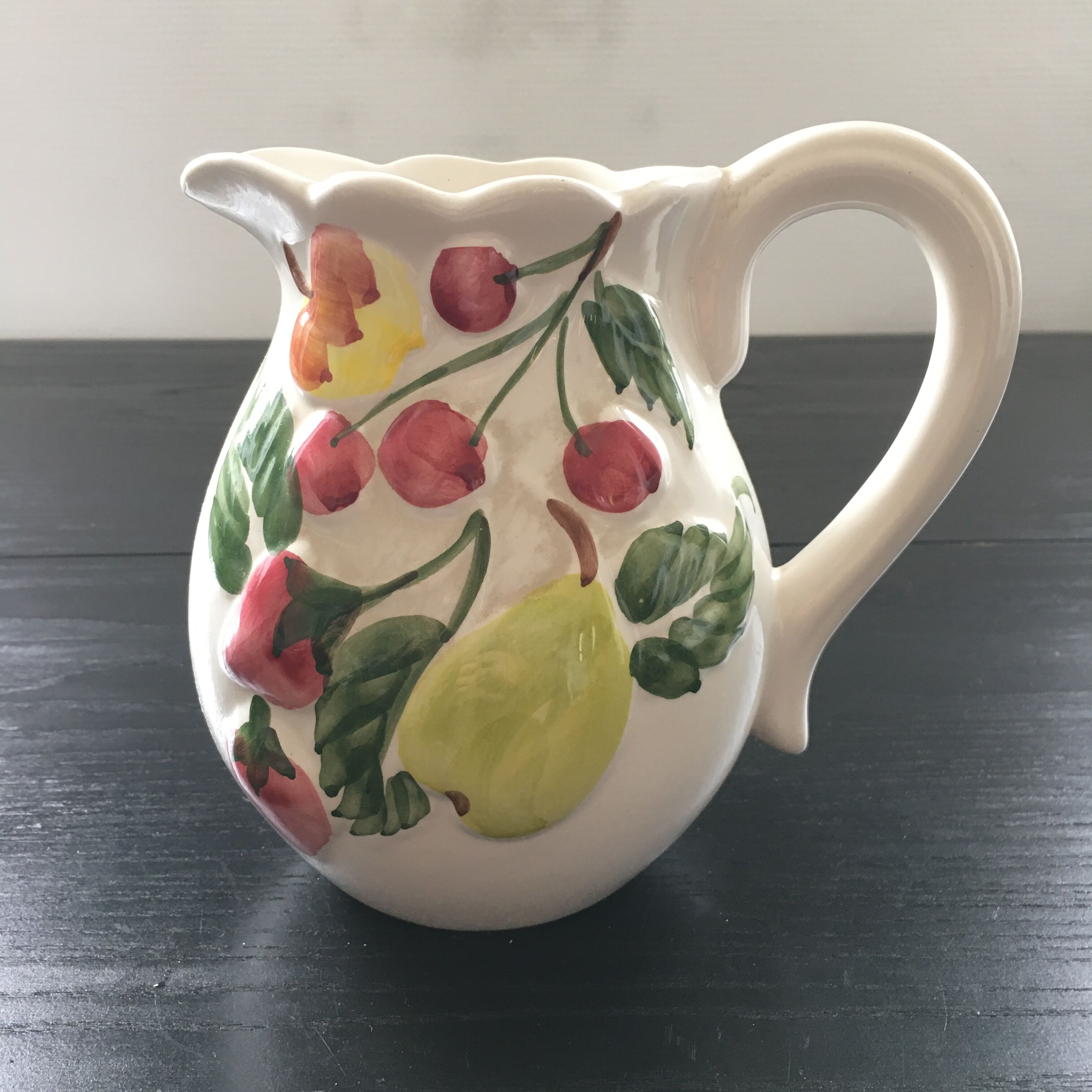 Fruit-decorated pitcher in slipware